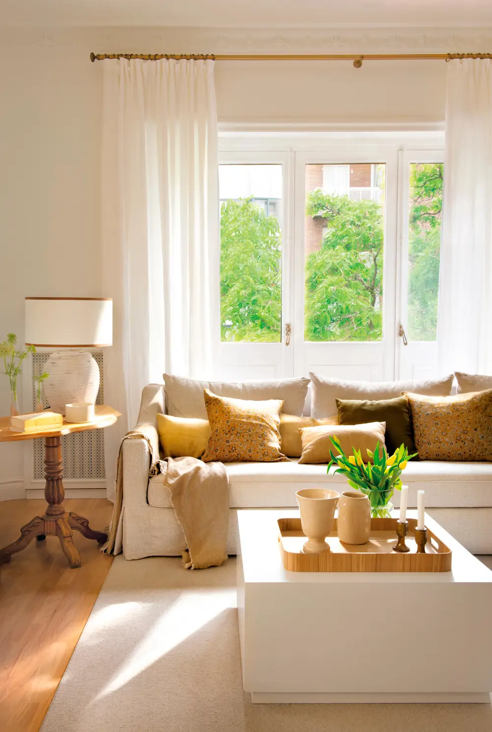 Salón con sofá neutro bajo la ventana 