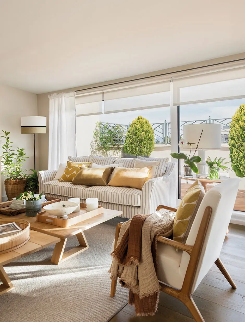 Salón con estor y cortinas detrás del sofá. 