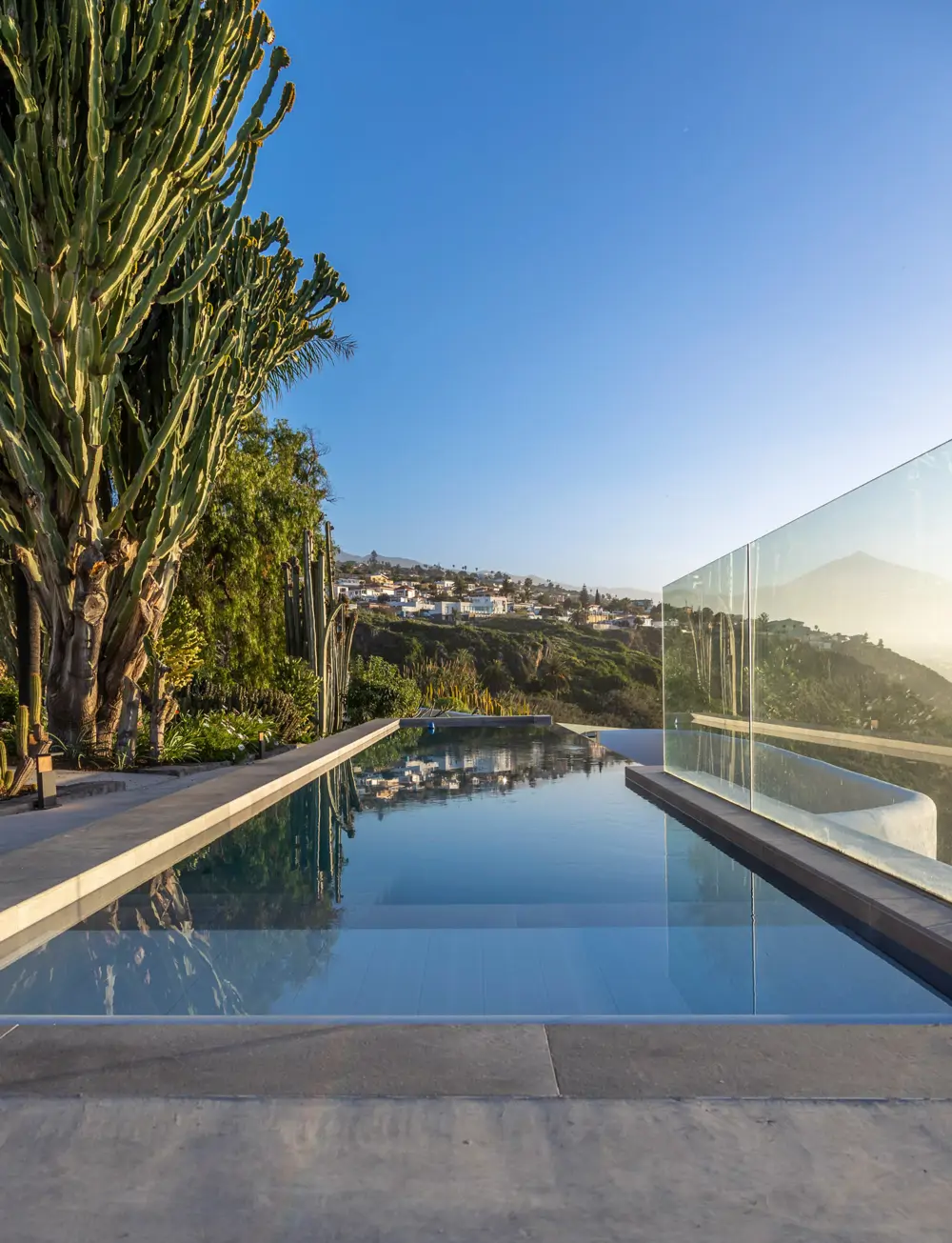 Piscina infinity en el proyecto Acantilado con el porcelánico Bottega Topo de Porcelanosa.