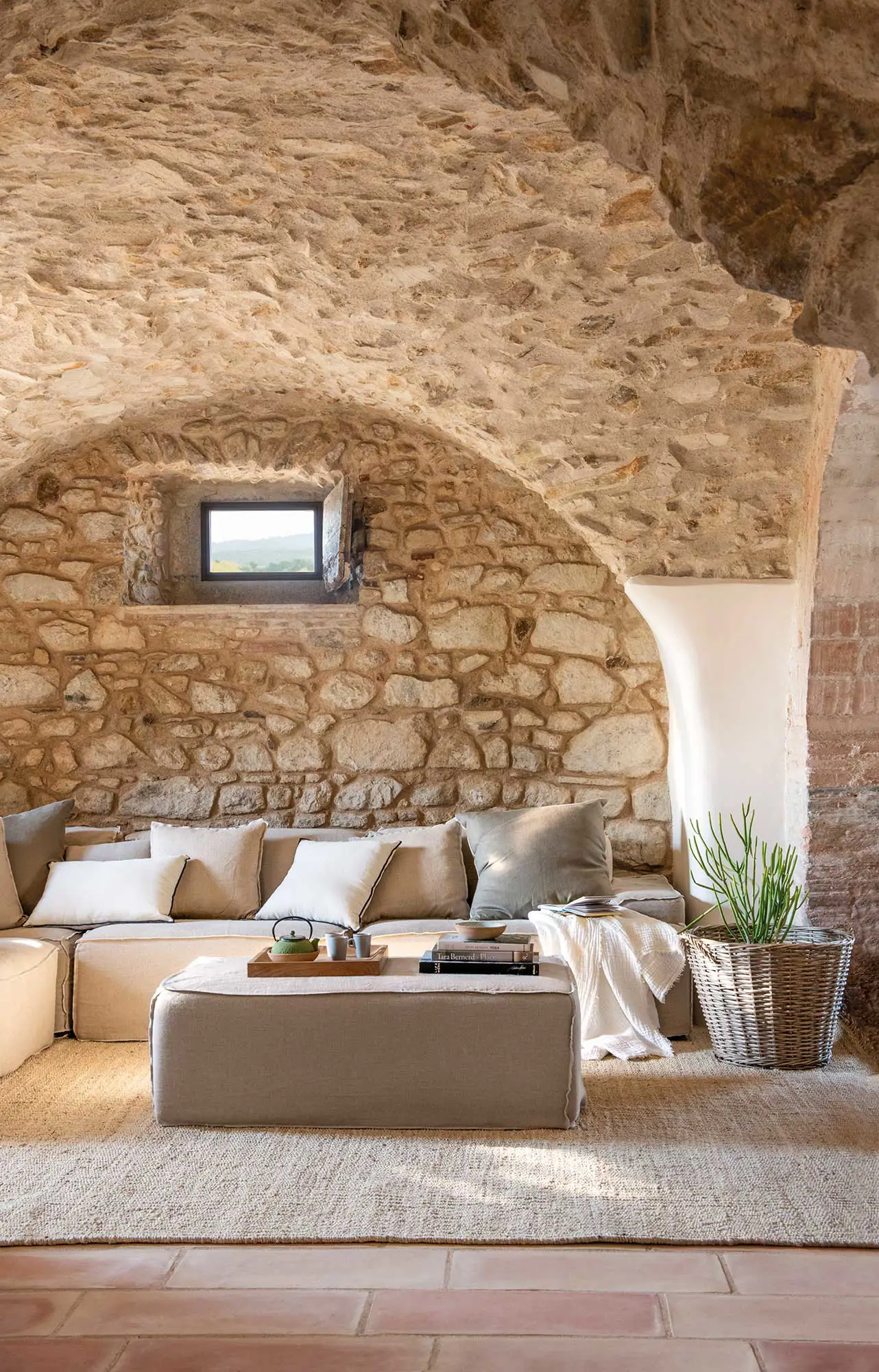 Un salón recibidor con paredes de piedra y sofá modular