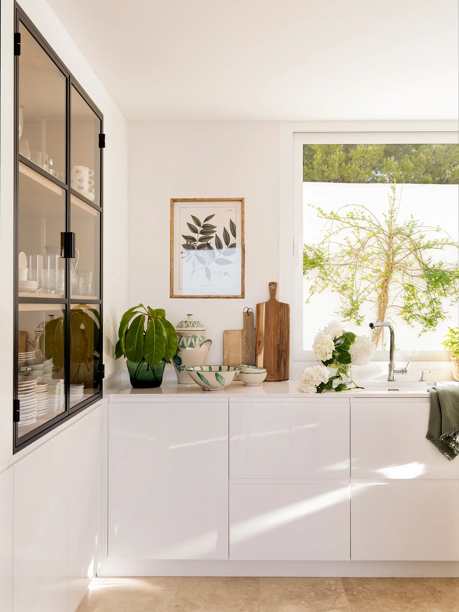 Cocina con muebles blancos y vitrina 