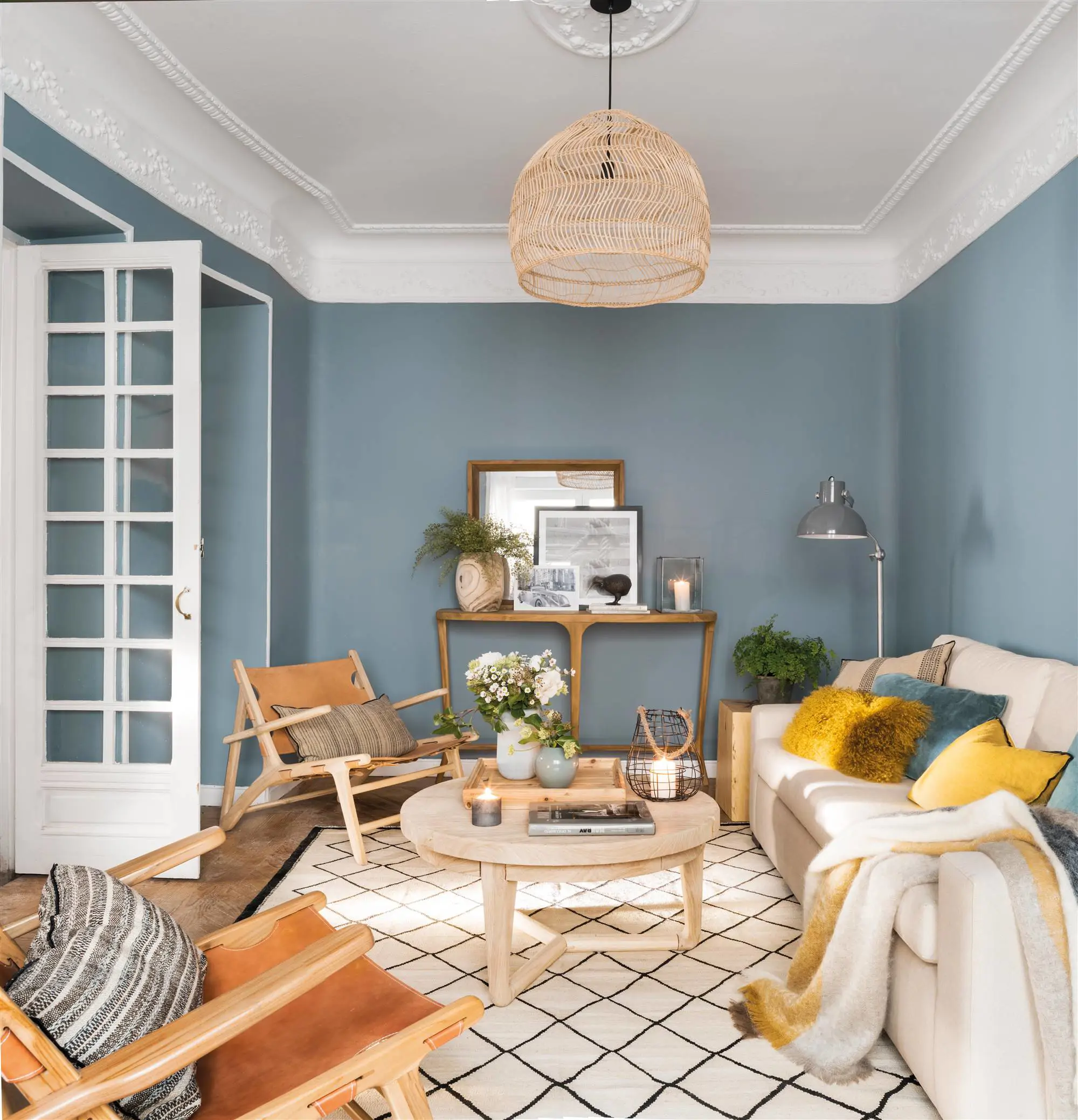 Salón con paredes pintadas en azul y sofá blanco.