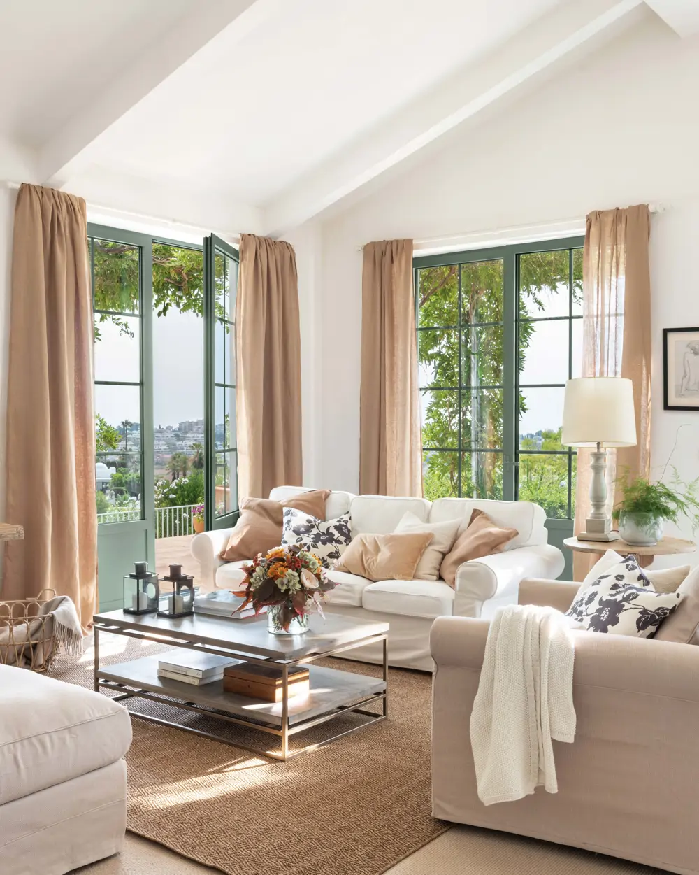 Salón con techos altos y cortinas en beige a juego con los cojines
