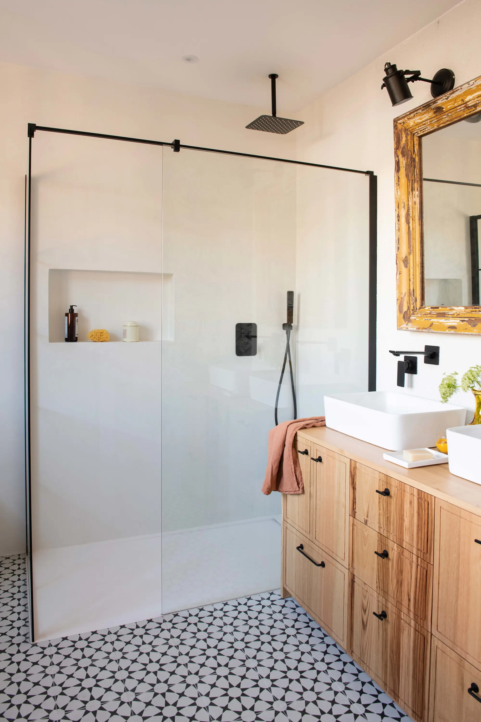 Baño con suelo hidraúlico, ducha y mueble de madera clara