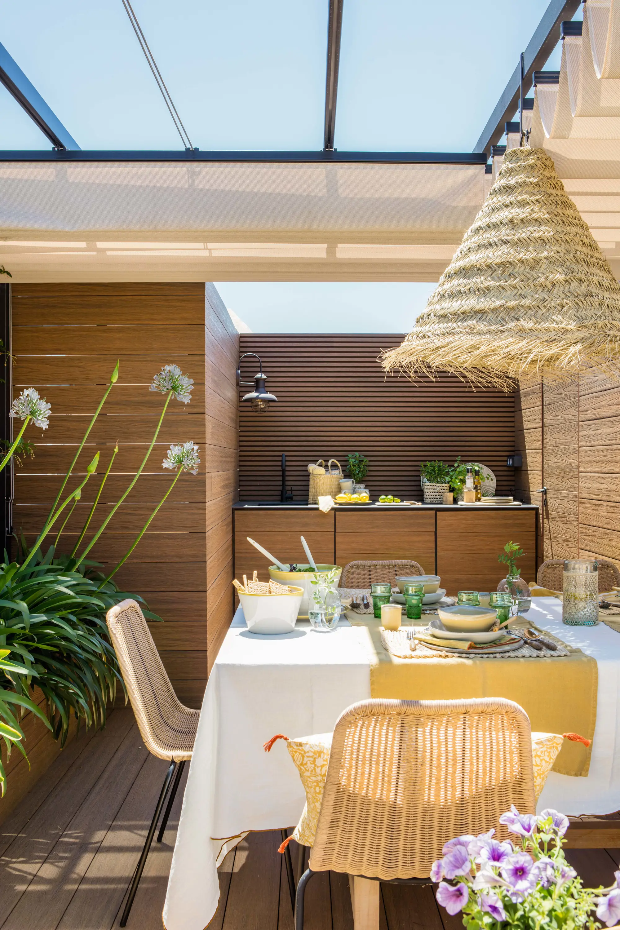 Comedor exterior cubierto con sillas y lámparas de fibra