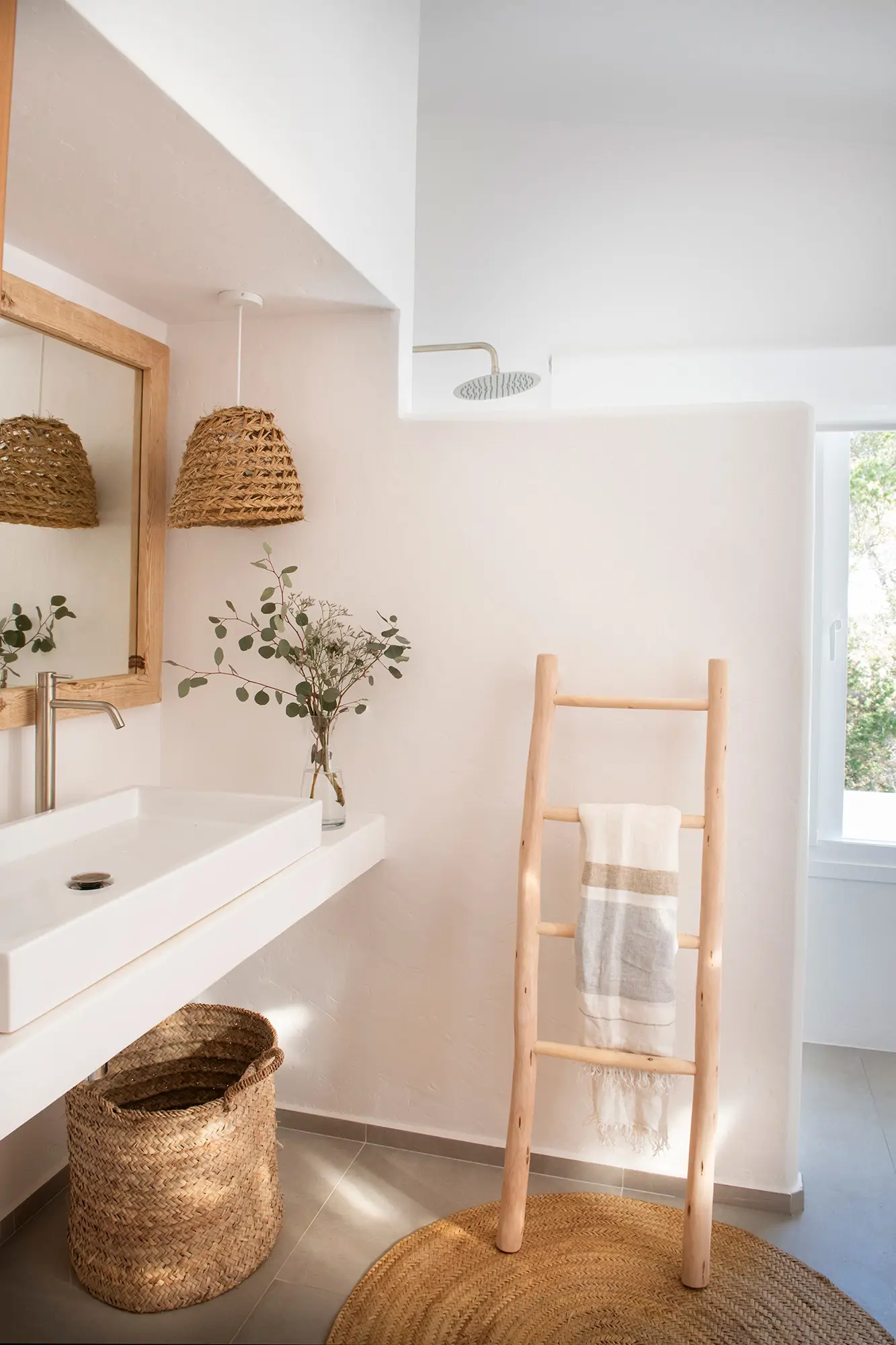 Baño rústico moderno con escalera-toallero de madera natural.