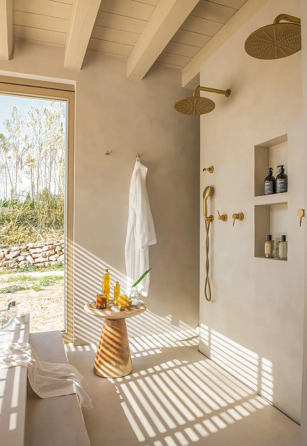 Baño con paredes de microcemento y techo de vigas de madera.