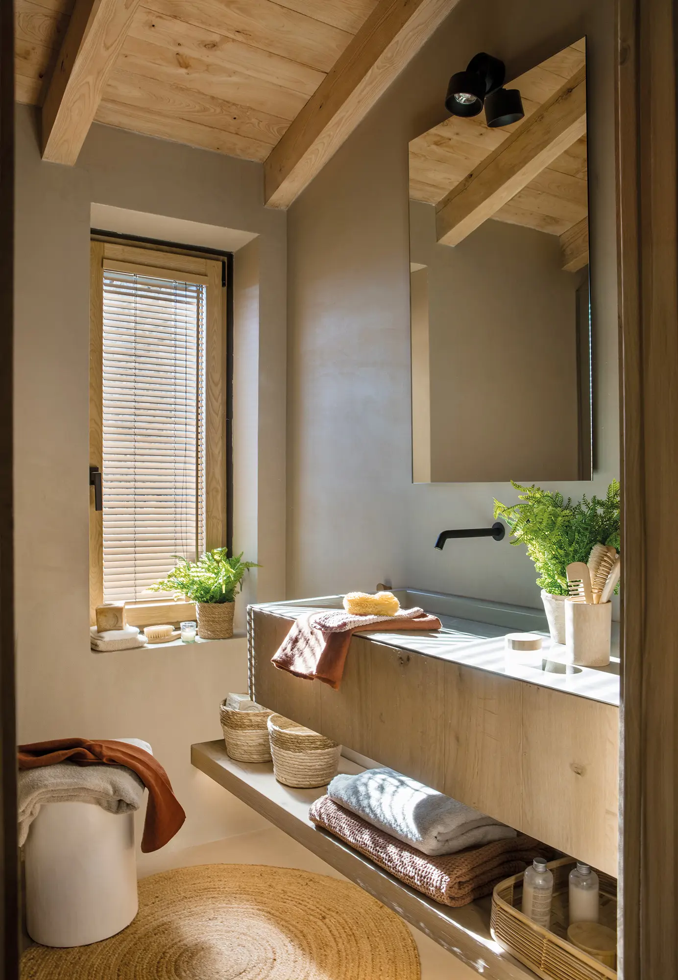 Baño con mueble volado y paredes de microcemento.
