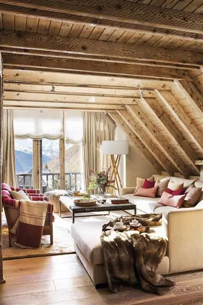 Salón con viguería vista de madera y sofá con chaise longue.