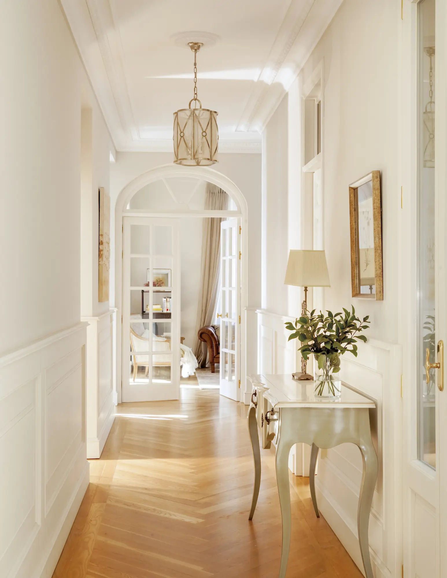 pasillo con consola arrimadero blanco y puerta cristal 