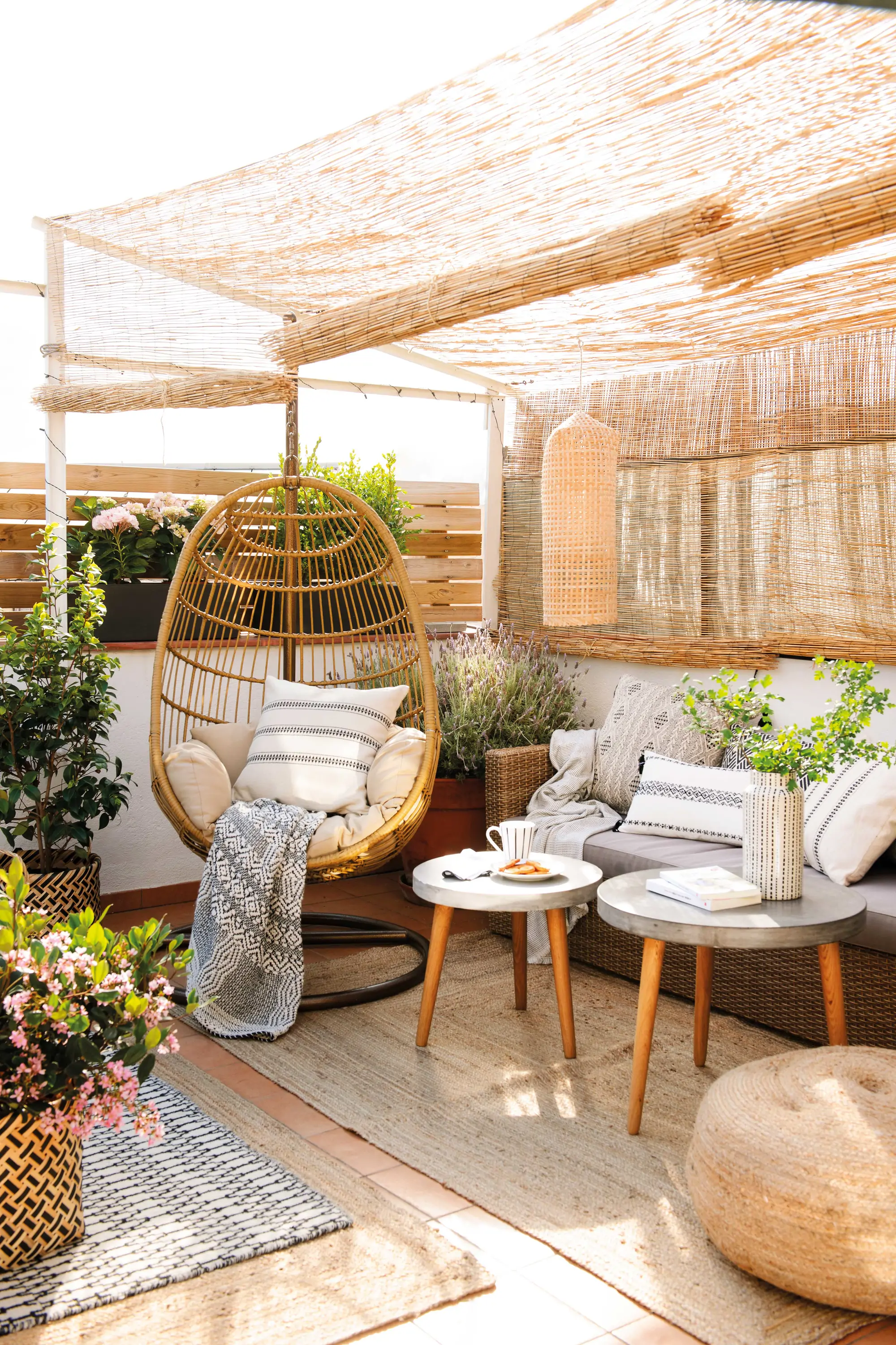 Terraza pequeña con toldo y sillón balancín.