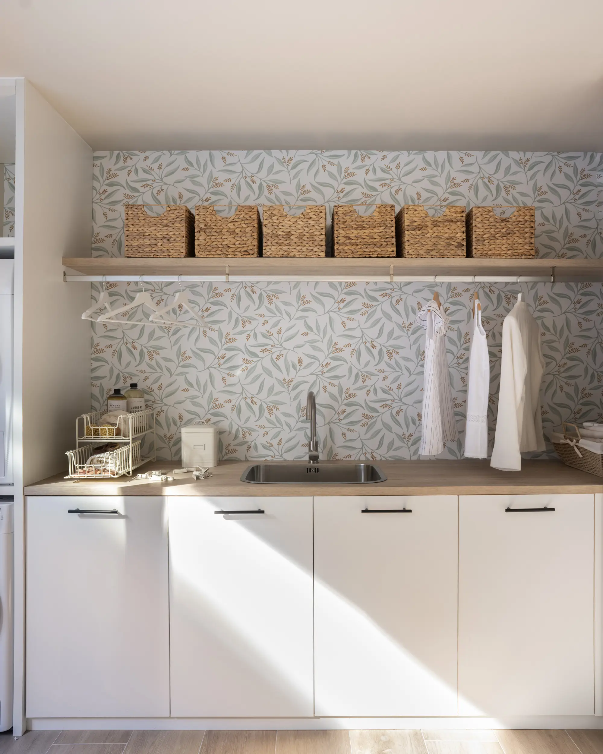 Cuarto de lavado con balda, papel pintado y cestas de fibra 