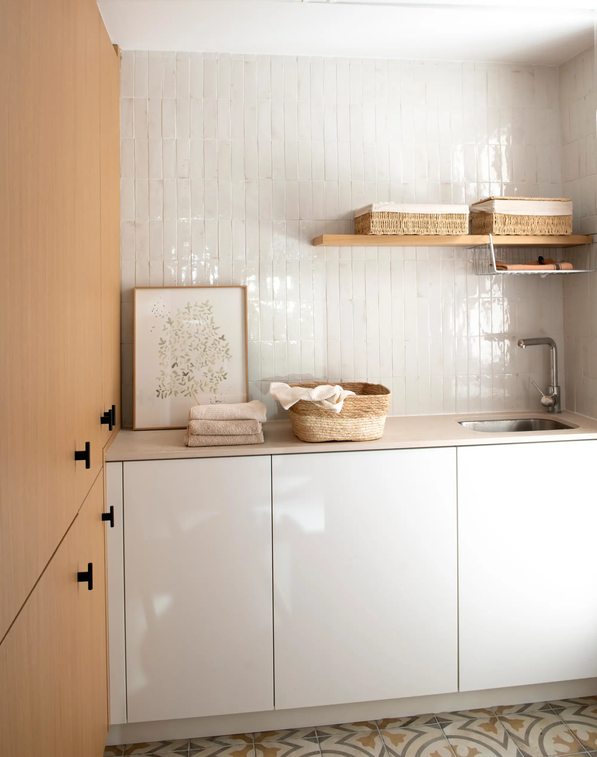 Lavadero con muebles en blanco y madera y revestimento cerámico 