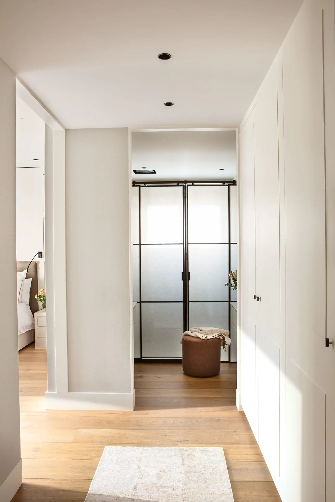 Vestidor junto al dormitorio con armarios de suelo a techo y puerta corredera al fondo