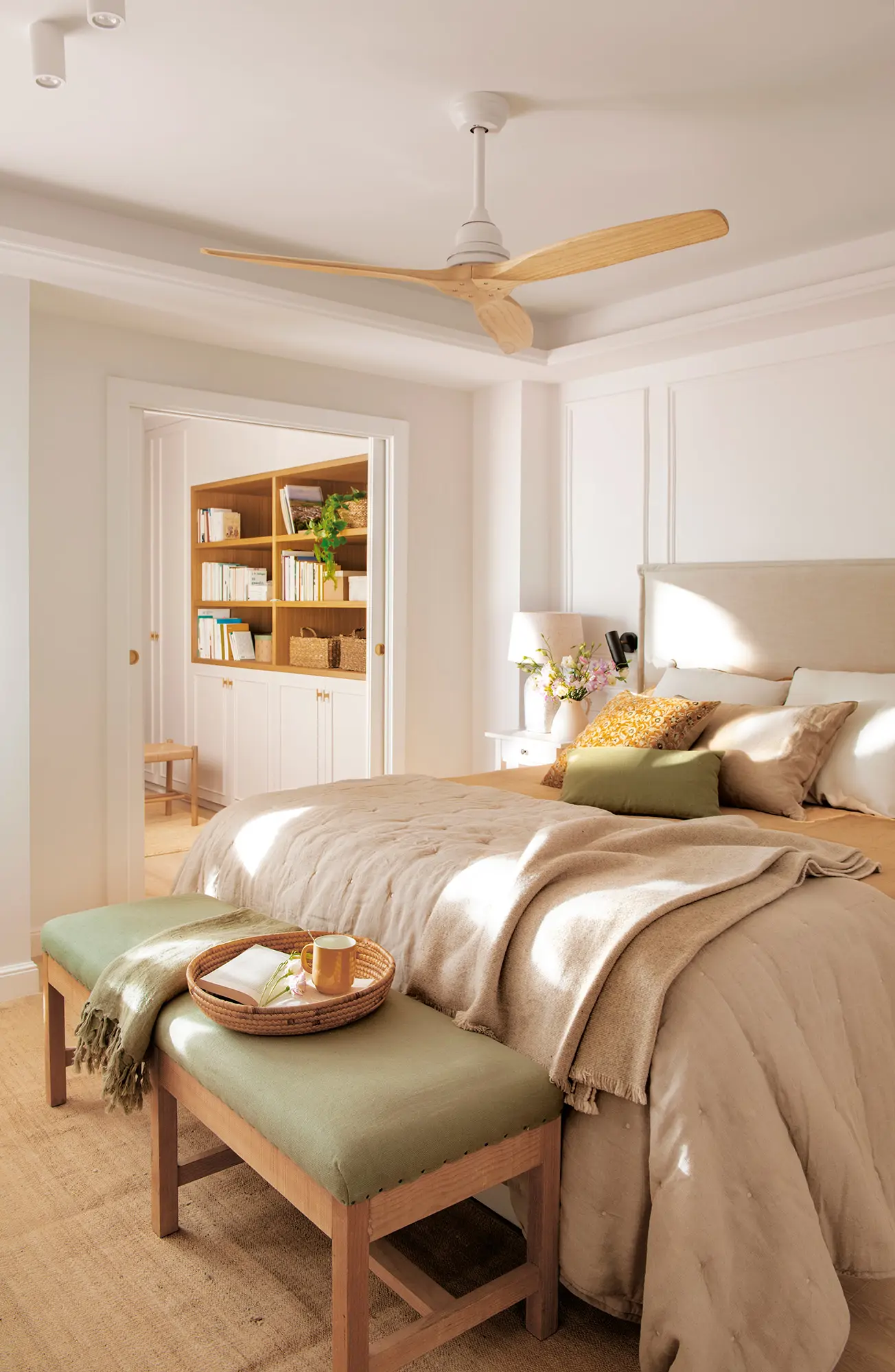 Dormitorio con ventilador y banqueta al pie de la cama