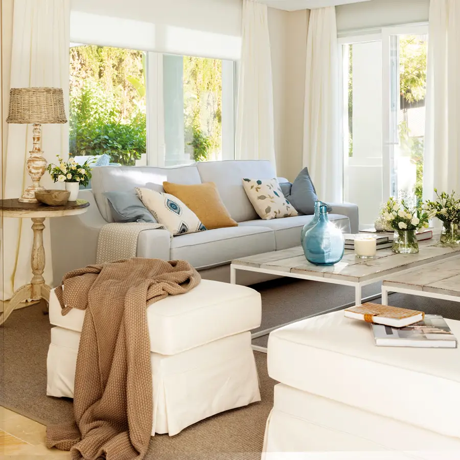 Salón con sofá en gris suave, dos mesas de centro gemelas y dos puffs_ 00438205