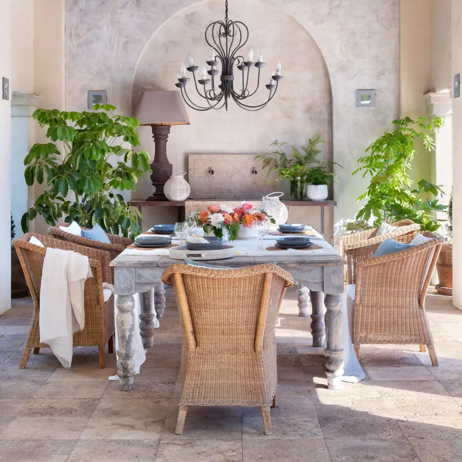 Comedor exterior con techo de vigas y sillones de fibra