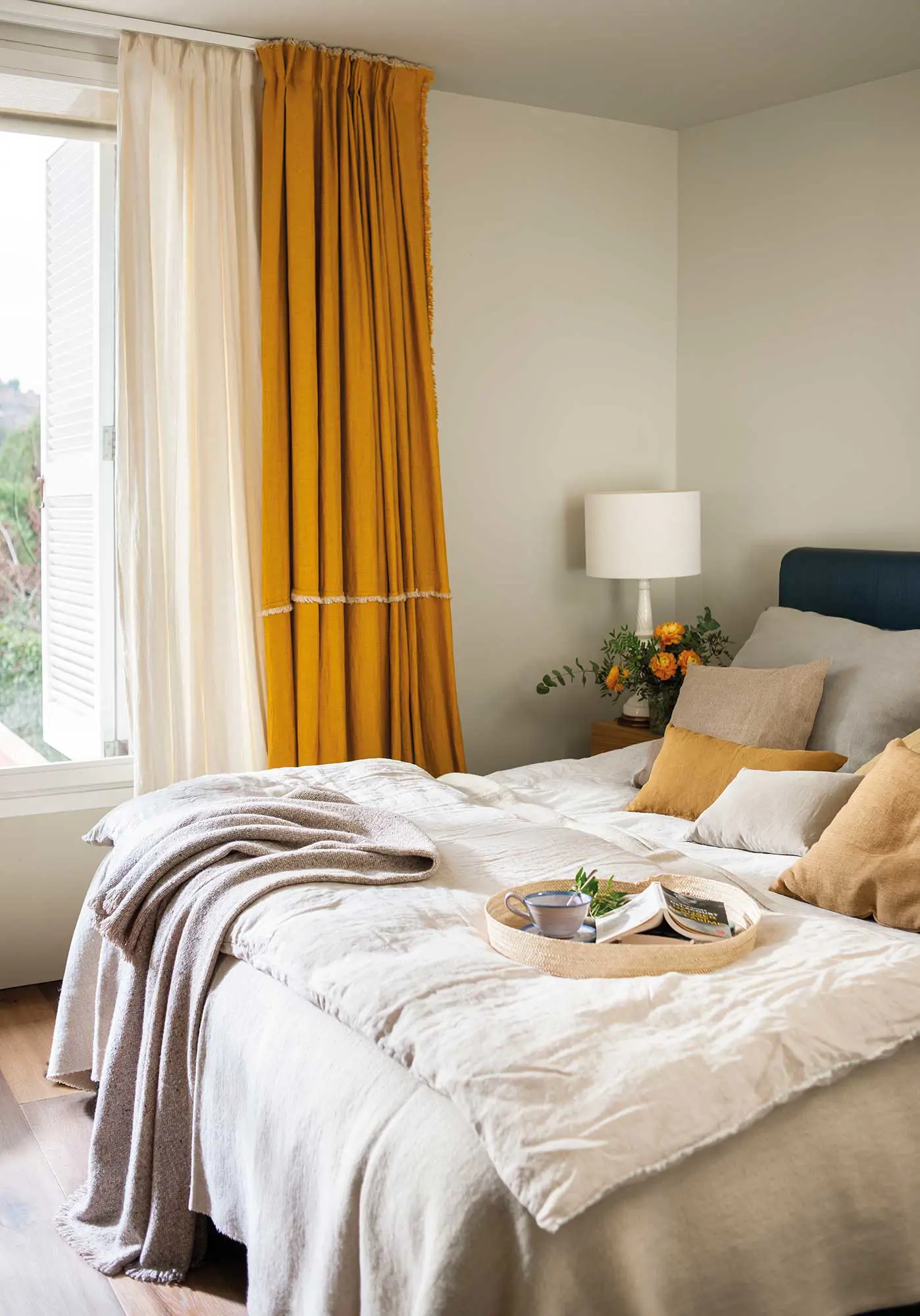 Dormitorio con visillo blanco y cortina mostaza