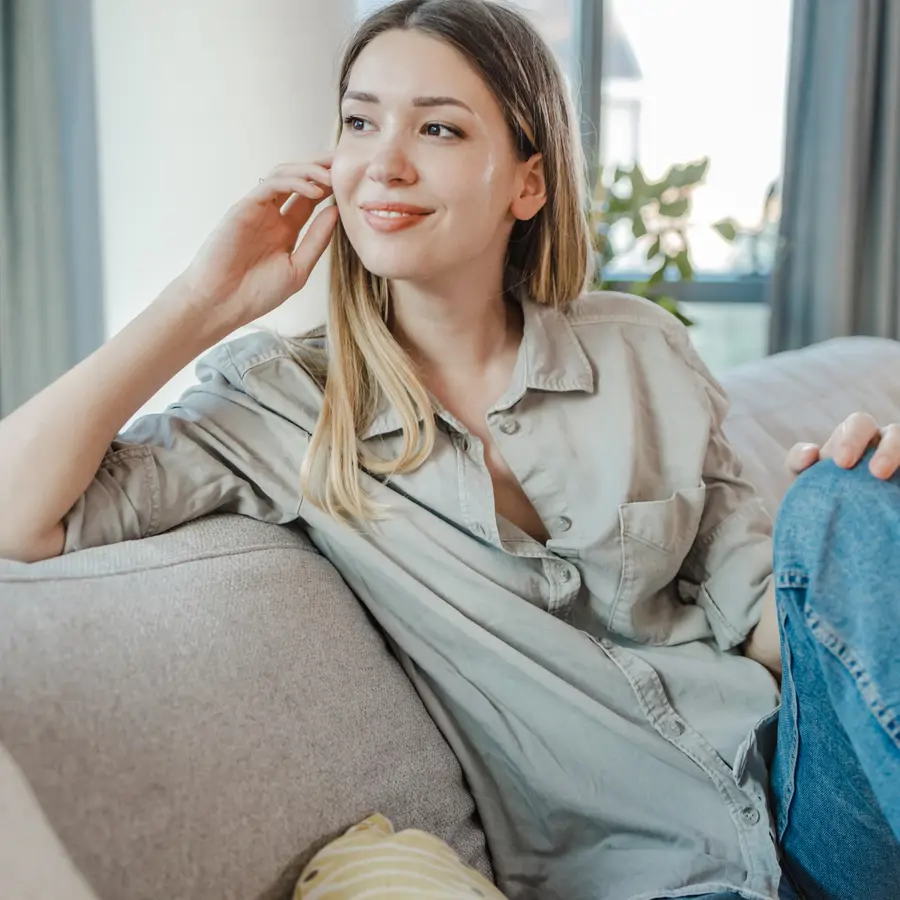 Mujer en el sofá con sandalias iStock
