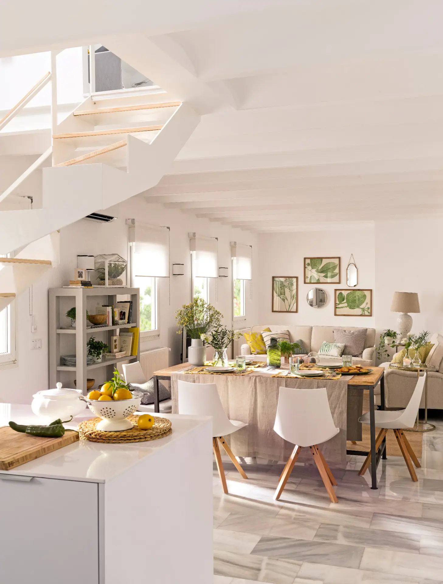 Cocina abierta al salón-comedor, decorado en tonos neutros y pinceladas verdes.