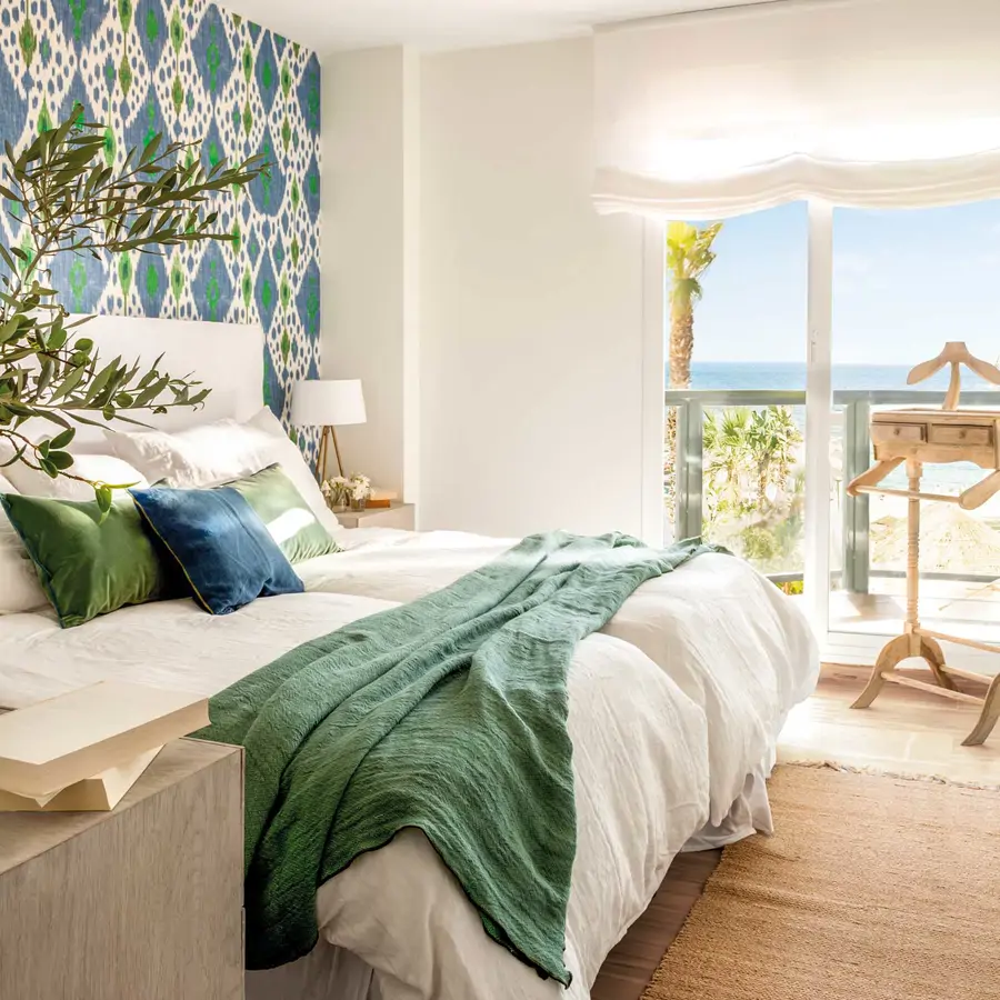 Dormitorio-blanco-con-pared-del-cabecero-con-papel-pintado-motivos-geométricos-azules-y-verdes-00542264