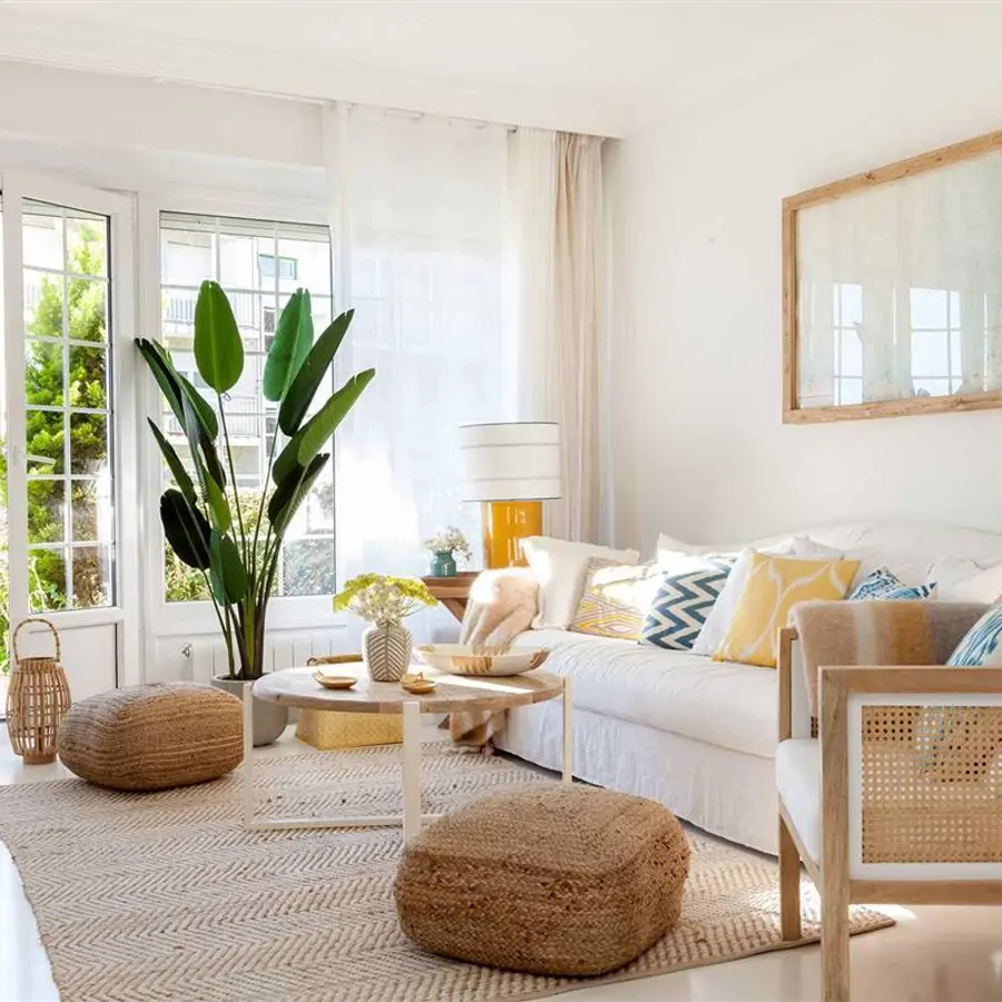 Salón blanco con gran sofá y butaca fibras