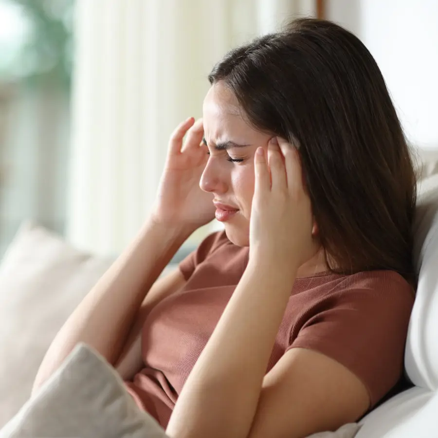 Mujer con dolor de cabeza en casa