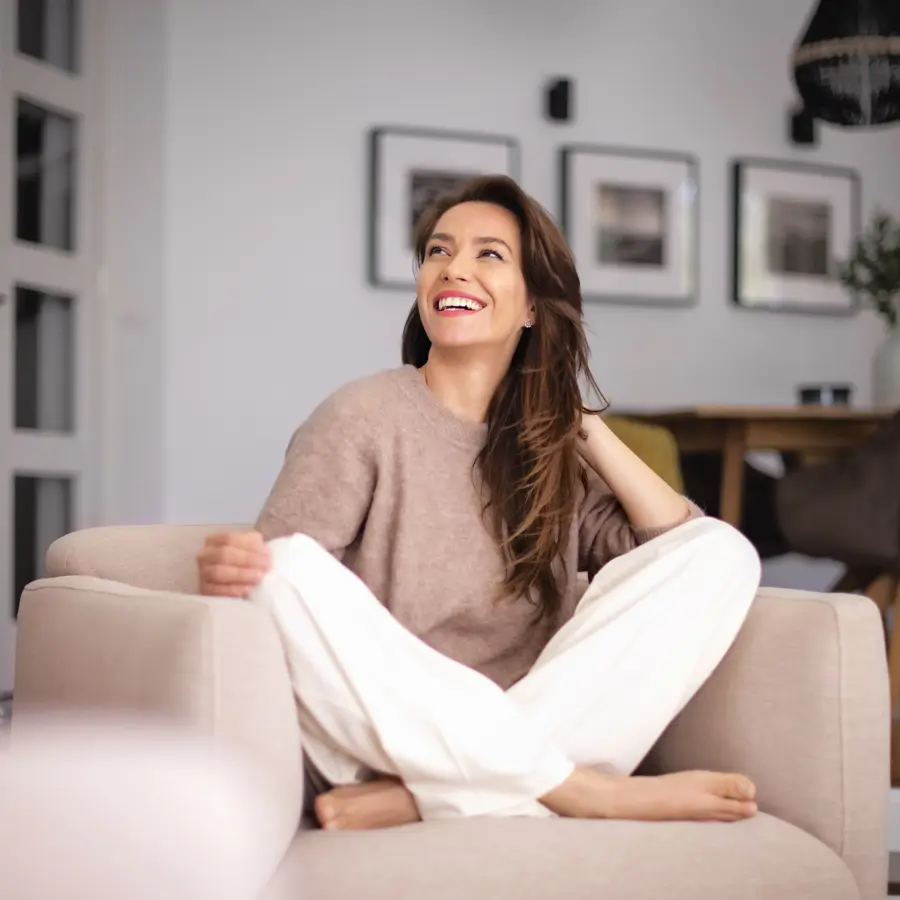 Mujer sentada en el sillón de su casa iStock
