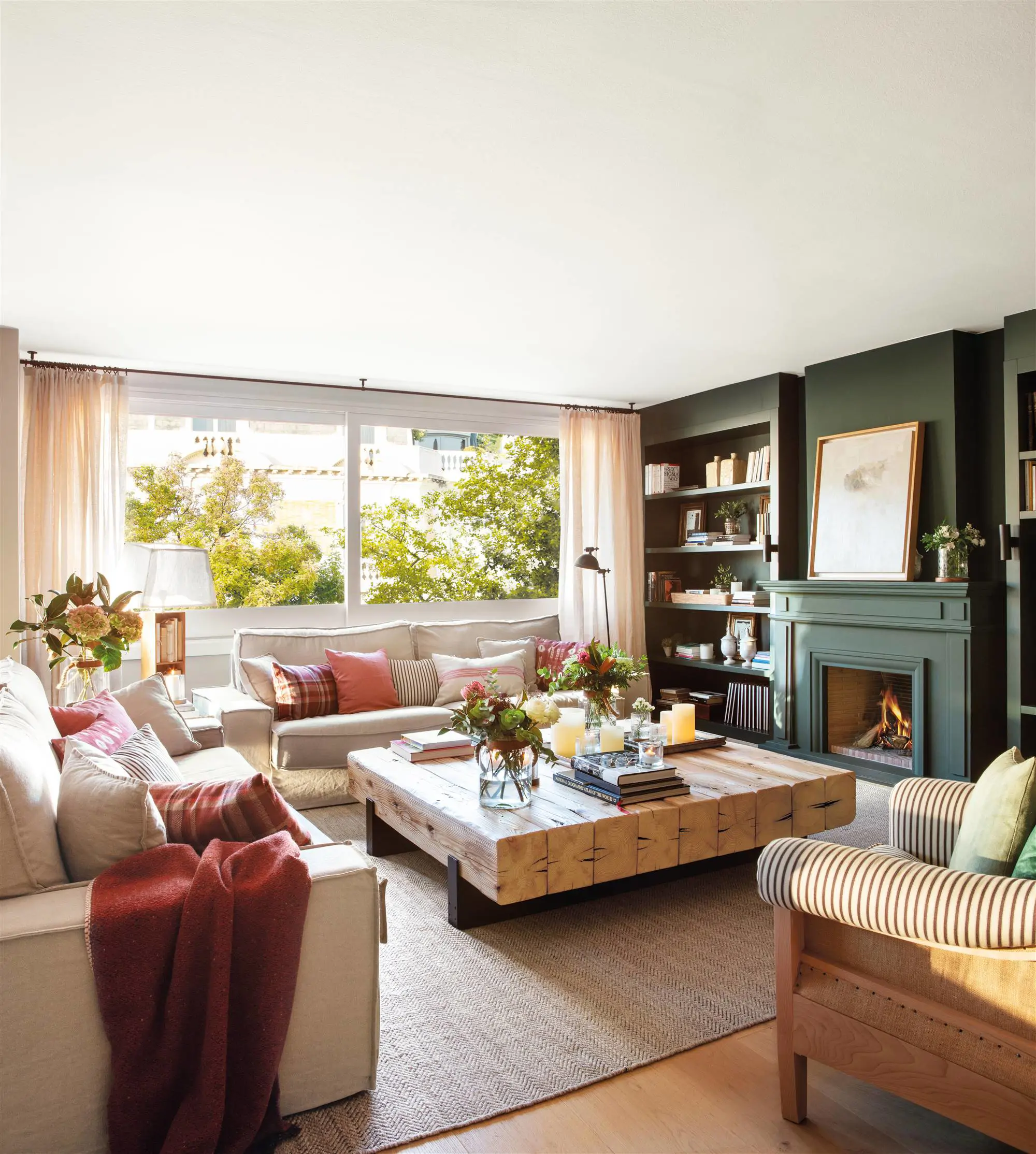 Salón con sofás neutros y estantería tipo boiserie pintada de verde