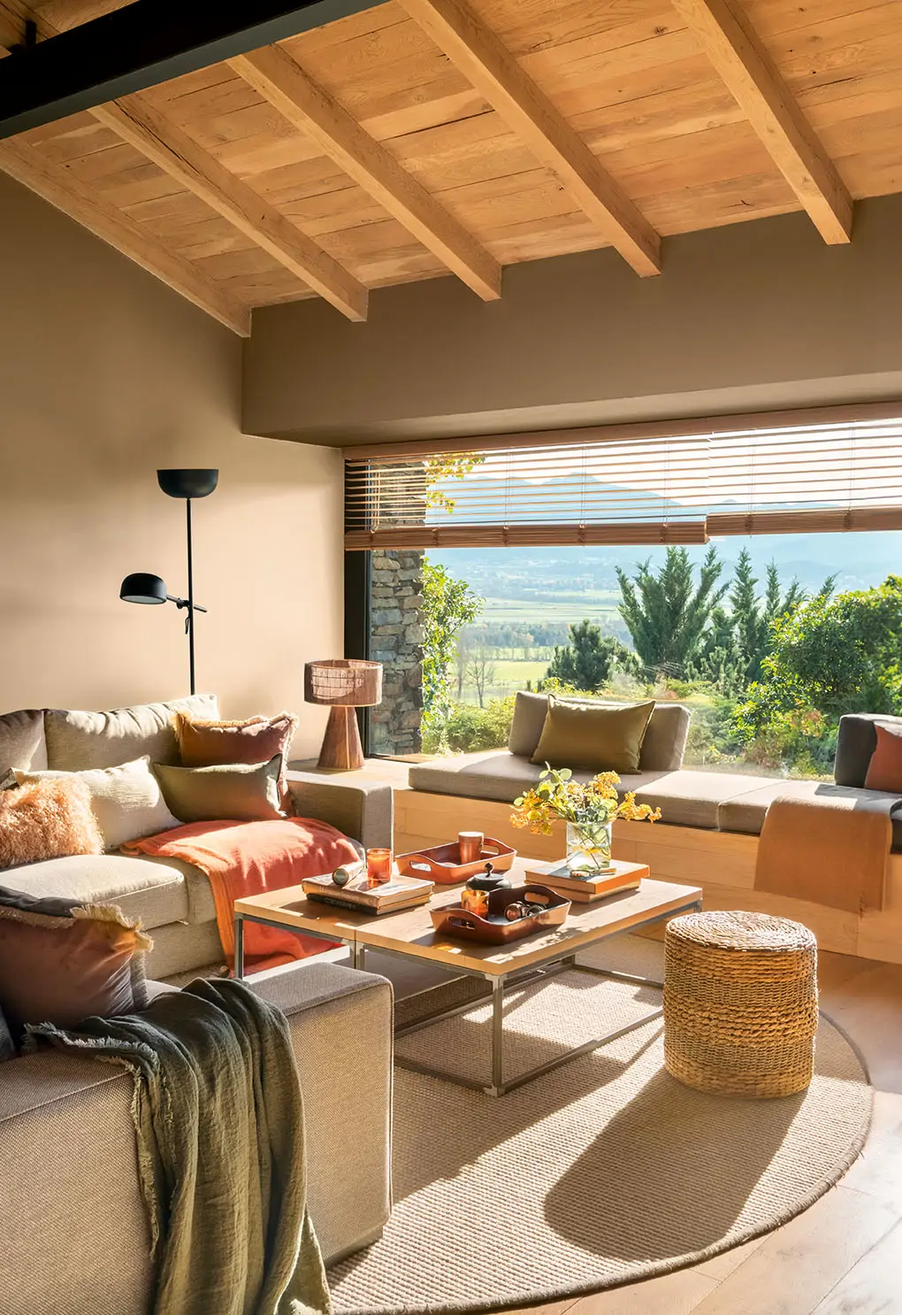 Un salón con techos de madera y gran ventanal panorámico