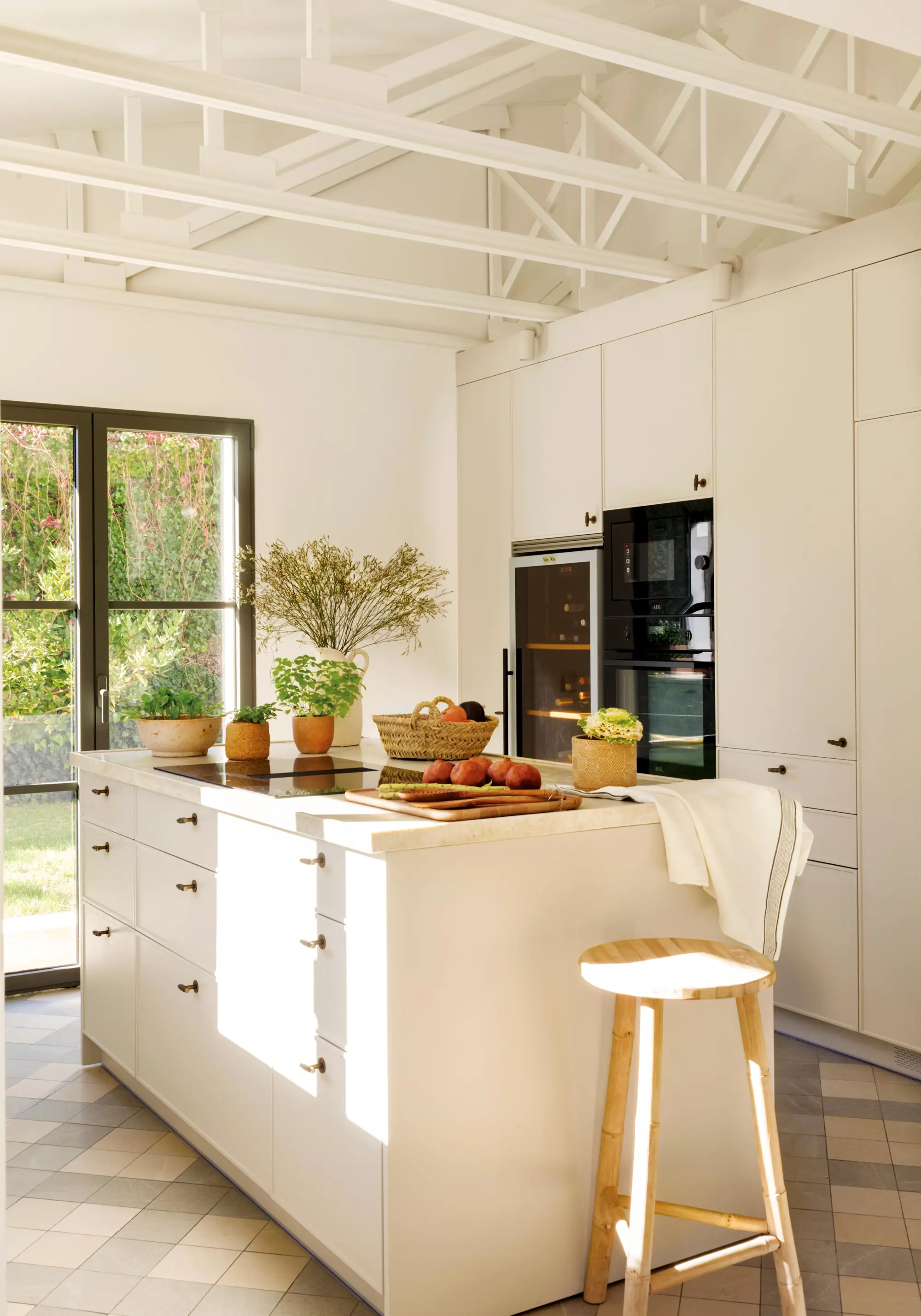Cocina blanca con isla y almacenamiento.
