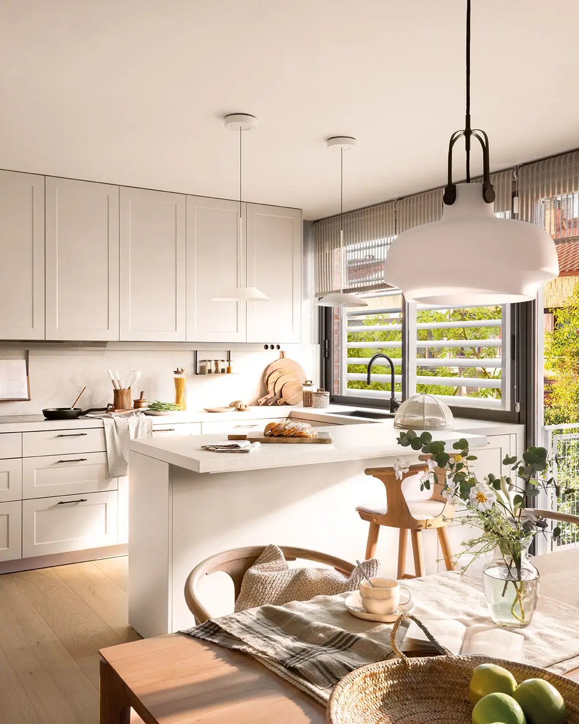 Una cocina blanca con península y molduras