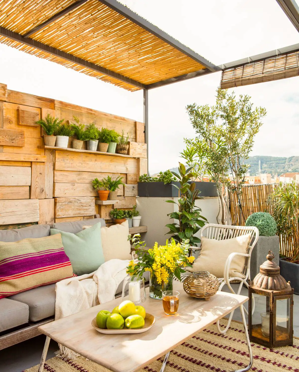 terraza-con-pergola-de-canamo-sofa-con-cojines-y-mesa-de-centro-con-manzanas-y-flores-sobre-alfombra-de-fibras-naturales-480668-o 7d57fdfe 1200x1492
