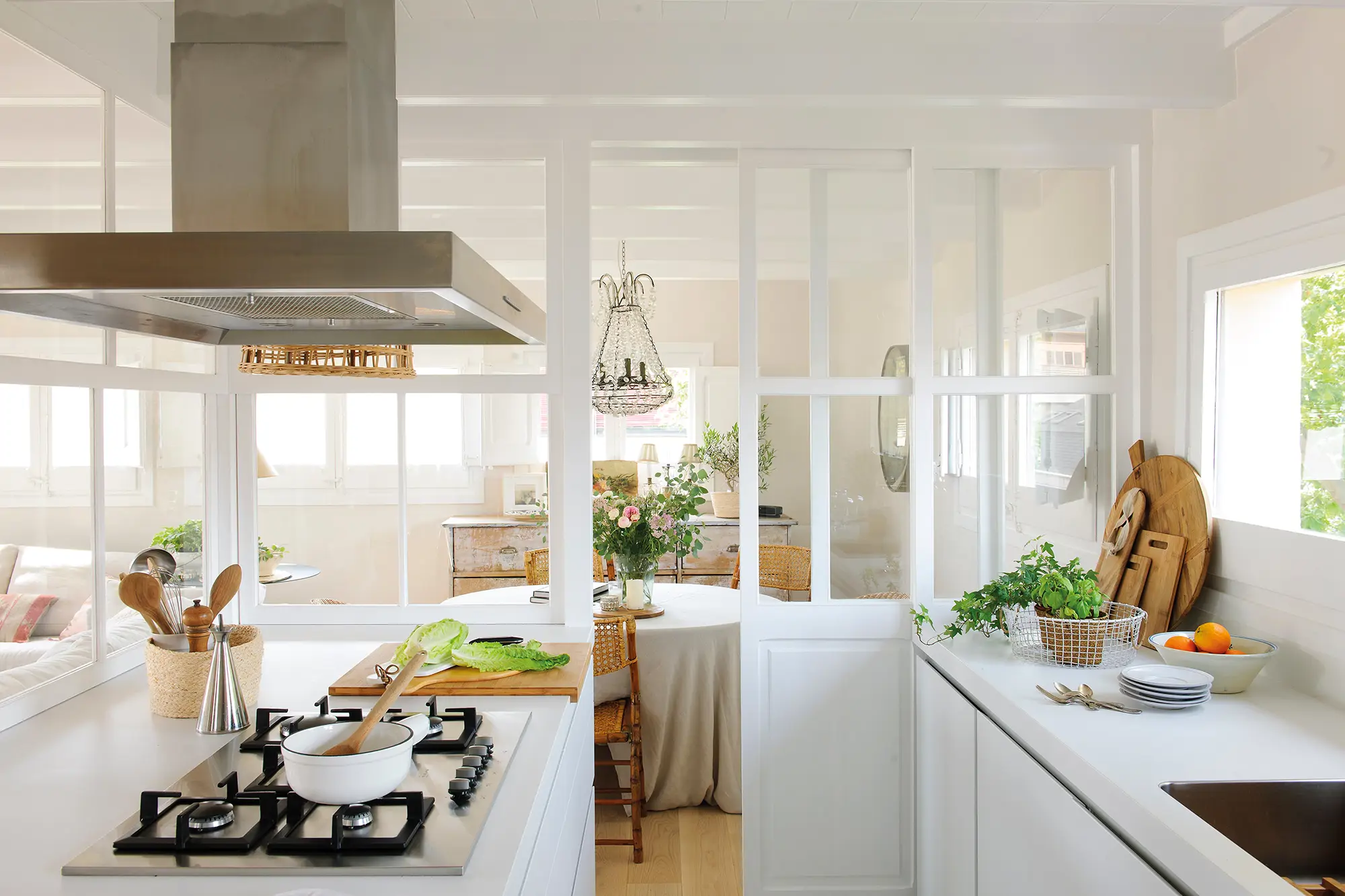 Cocina blanca con campana extractora de isla.