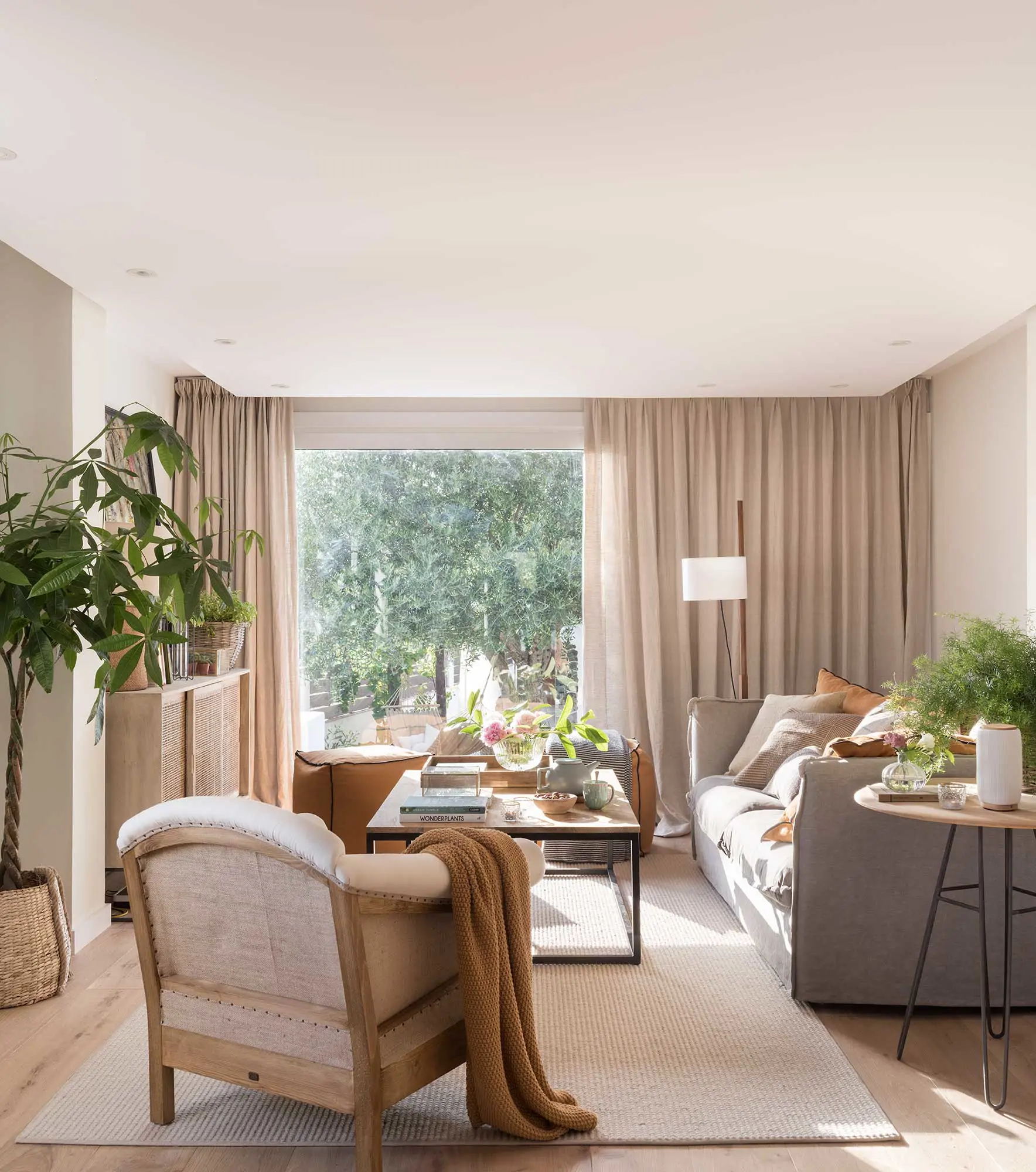 Salón pequeño en tonos topo con sofá y butaca tapizada