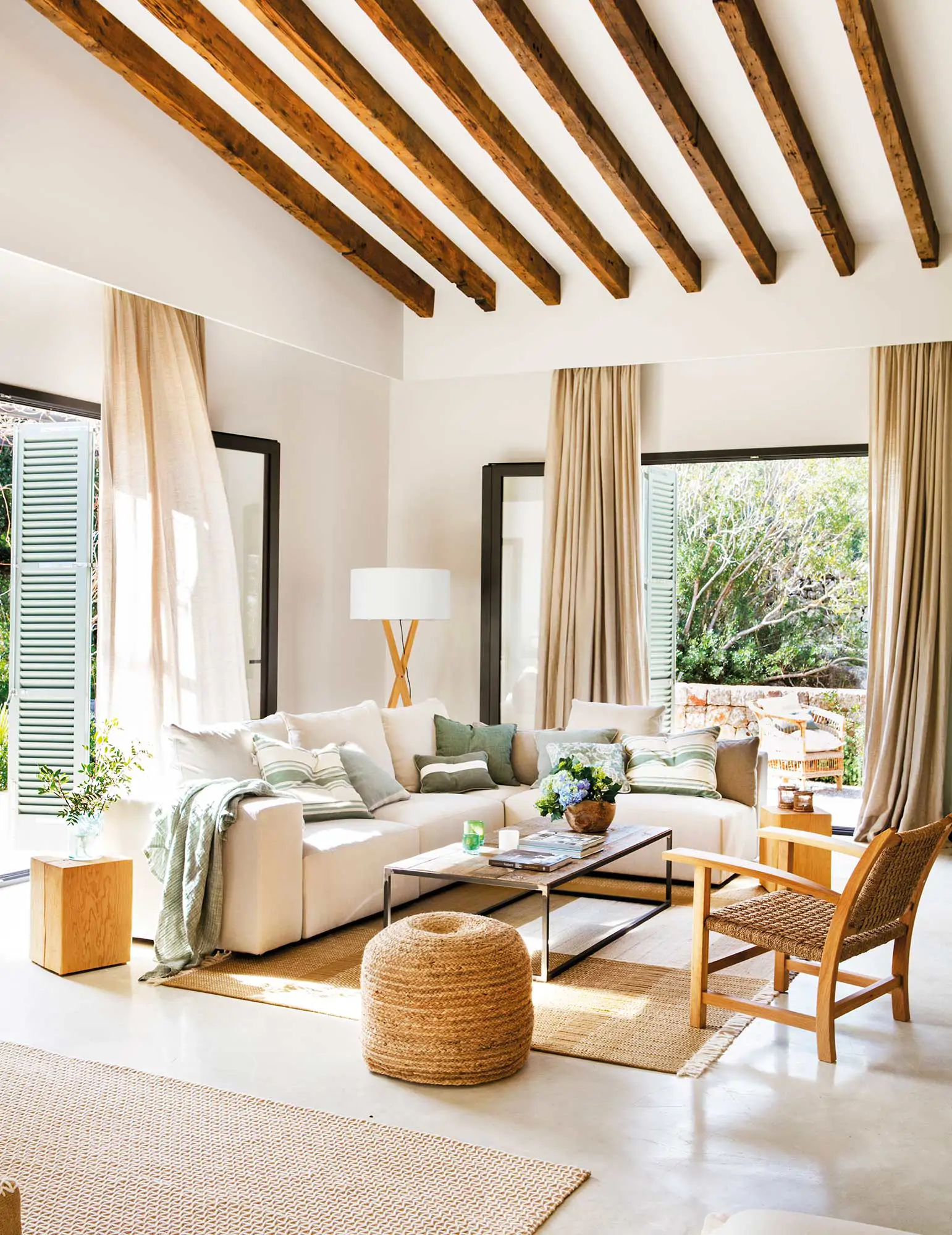 Salón de verano con vigas y sofá esquinero blanco