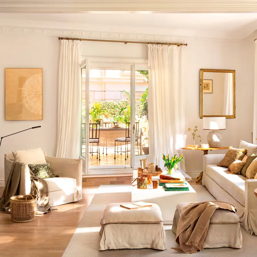 Salón con sofá, butaca y pufs con salida al exterior