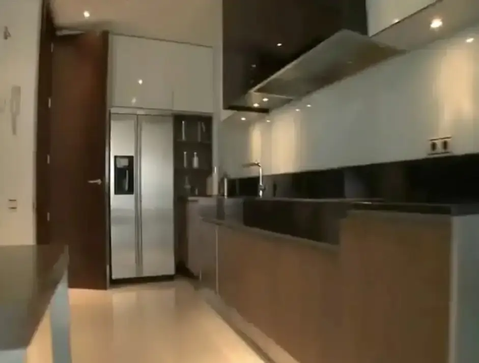 Una cocina con muebles de madera y detalles en negro