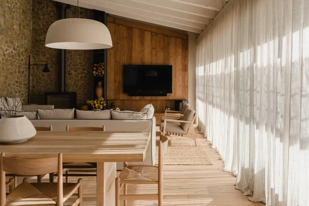 Salón abierto cocina y comedor de madera rústico y paredes piedra
