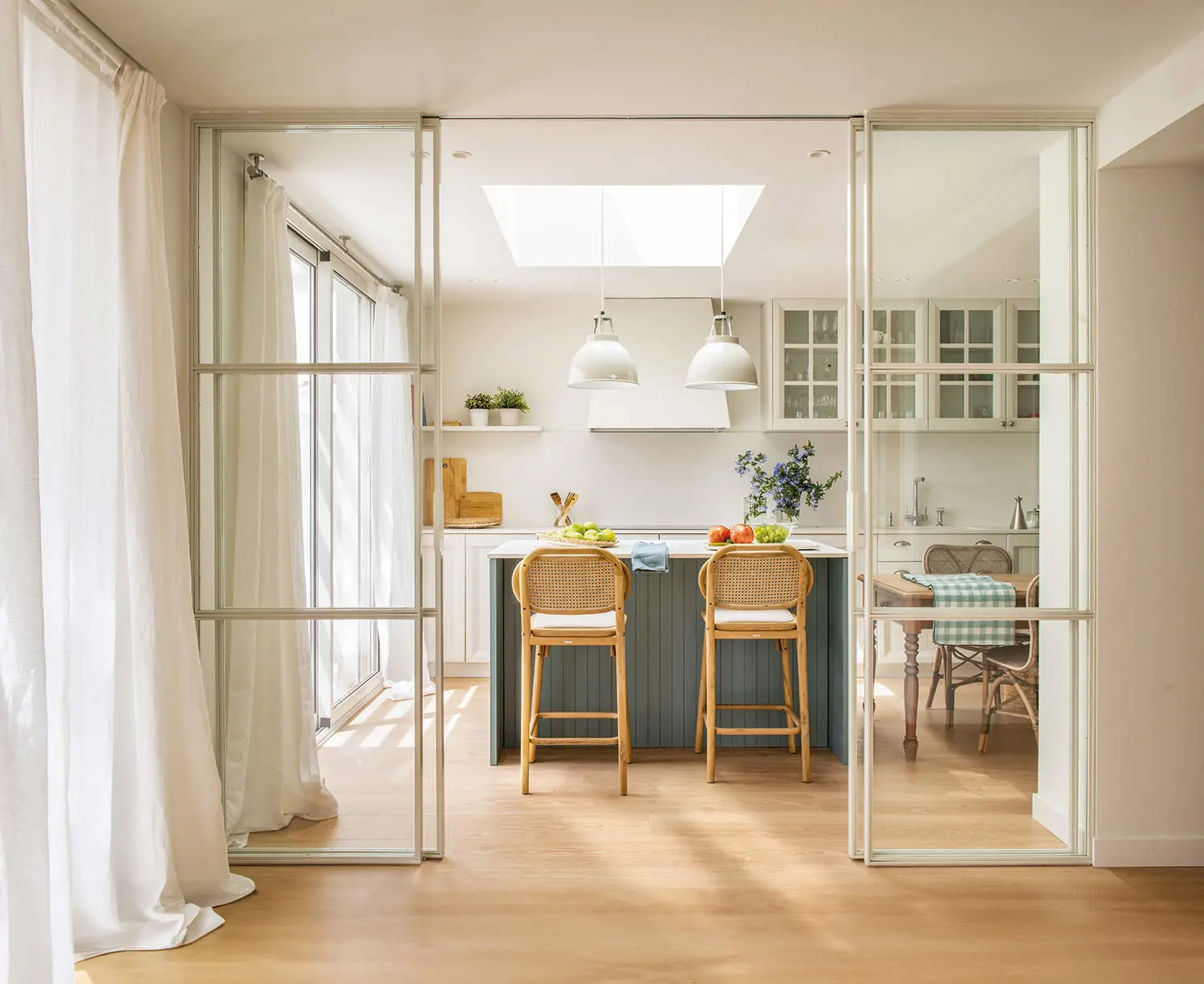Cocina con isla azul y puertas de cristal