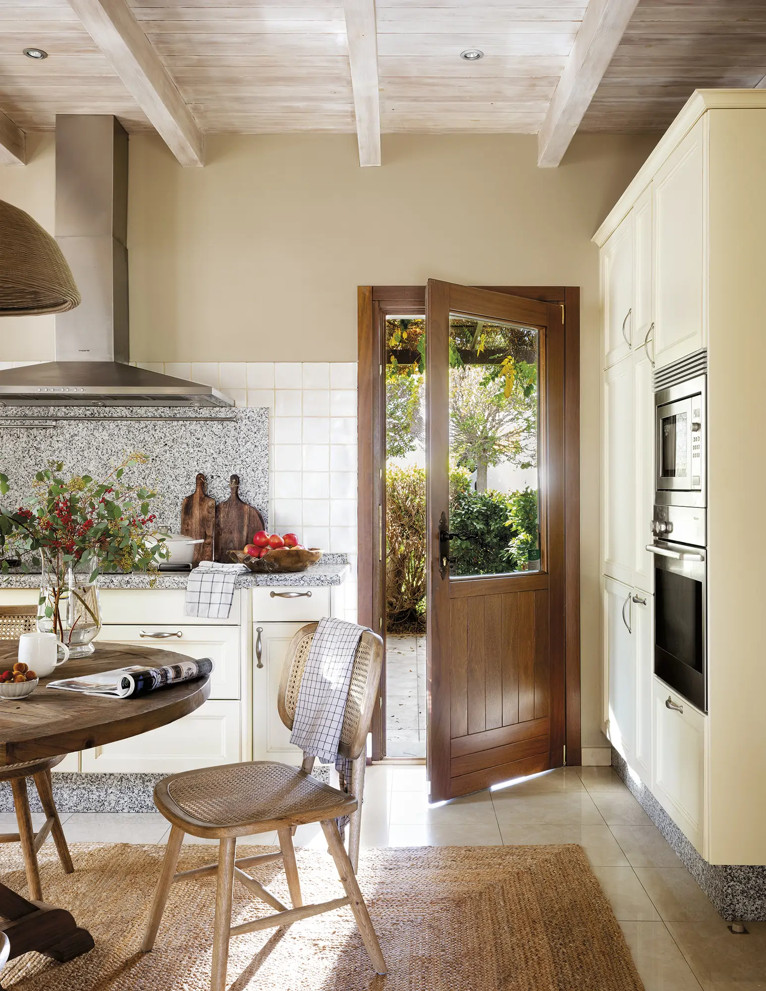 Cocina con office de estilo rústico y puerta de madera