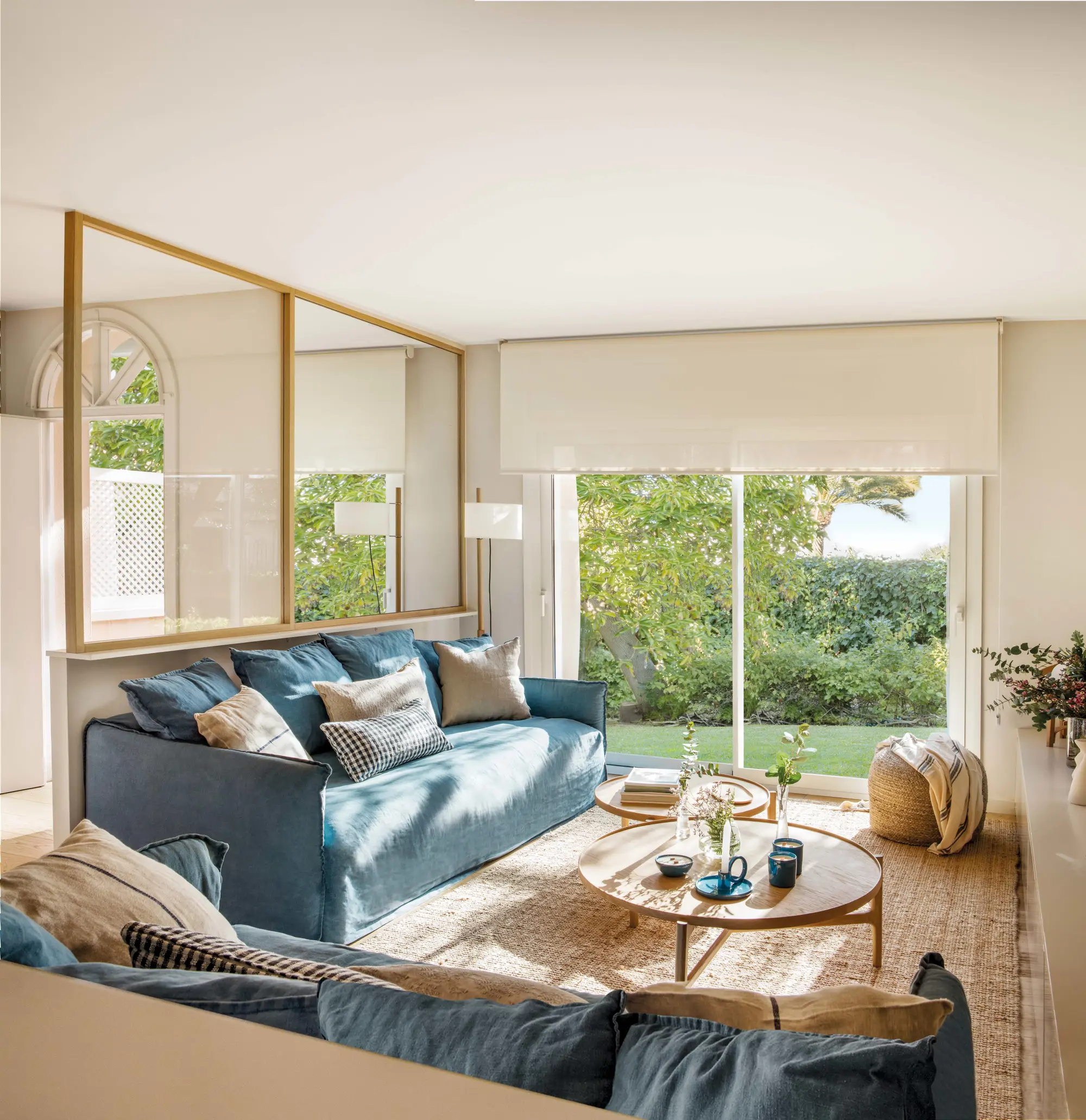 Salón pequeño con sofá azul y cerramiento acristalado