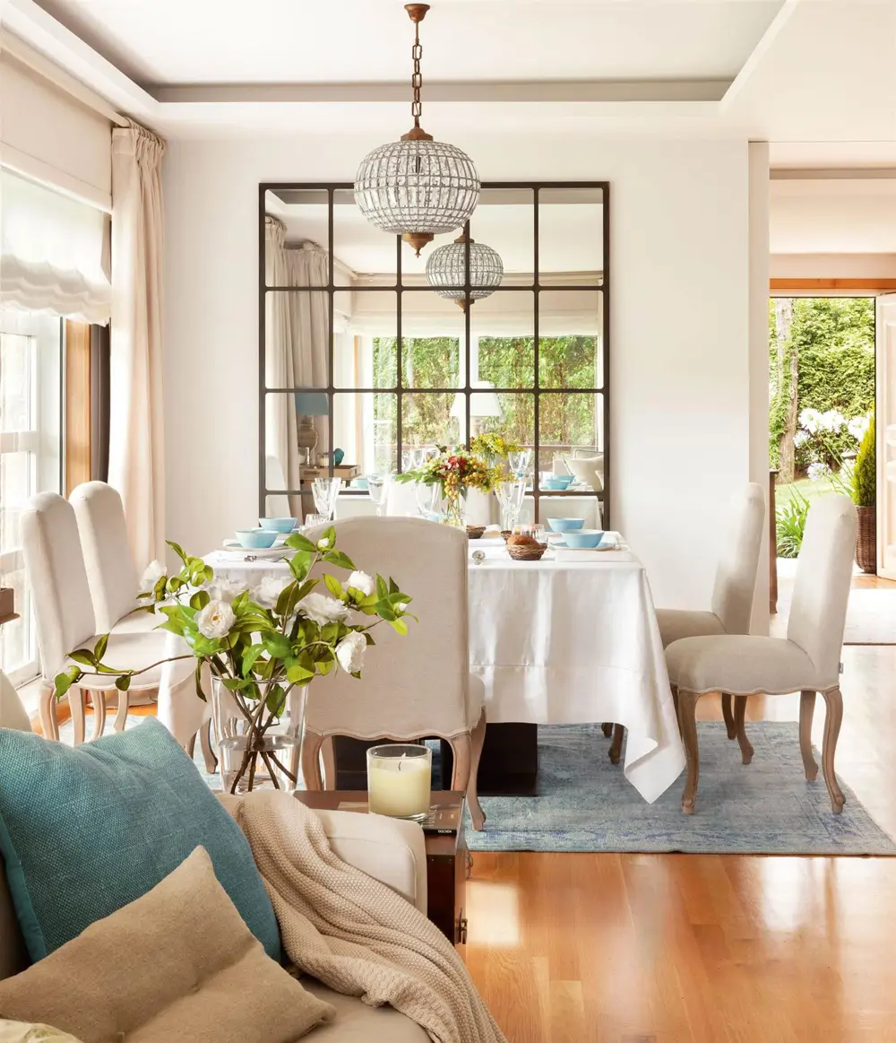 espejo-con-cuarterones-metalicos-frente-a-ventana-en-un-comedor-con-lampara-redonda-de-cristal 00410977 
