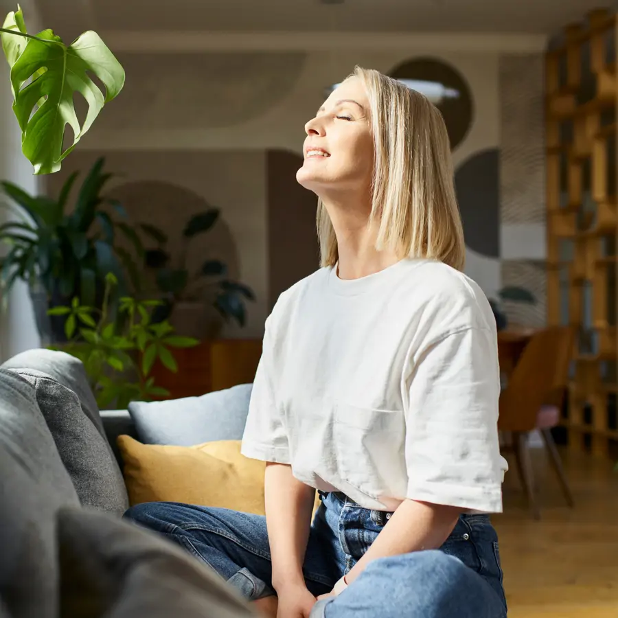 Mujer en su casa con ventilador iStock