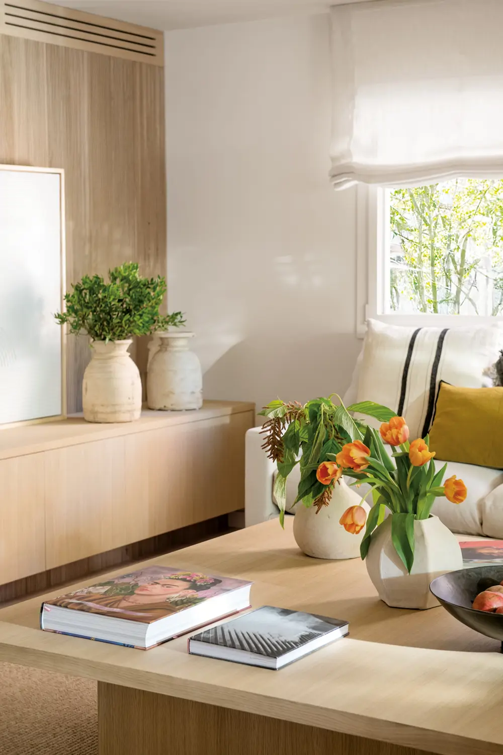 Salón elegante y cálido con mesa de centro de madera natural y flores
