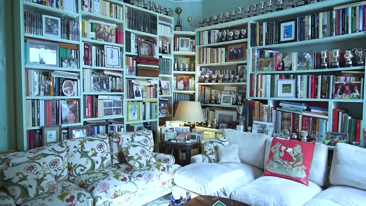 Una zona de estar con biblioteca que recubre todas las paredes