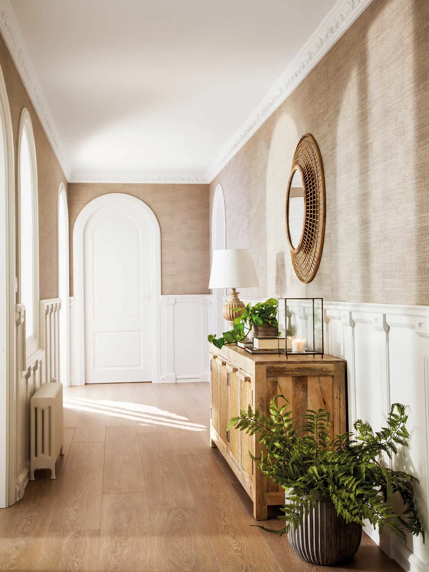 Recibidor con mueble de madera y espejo redondo de pared