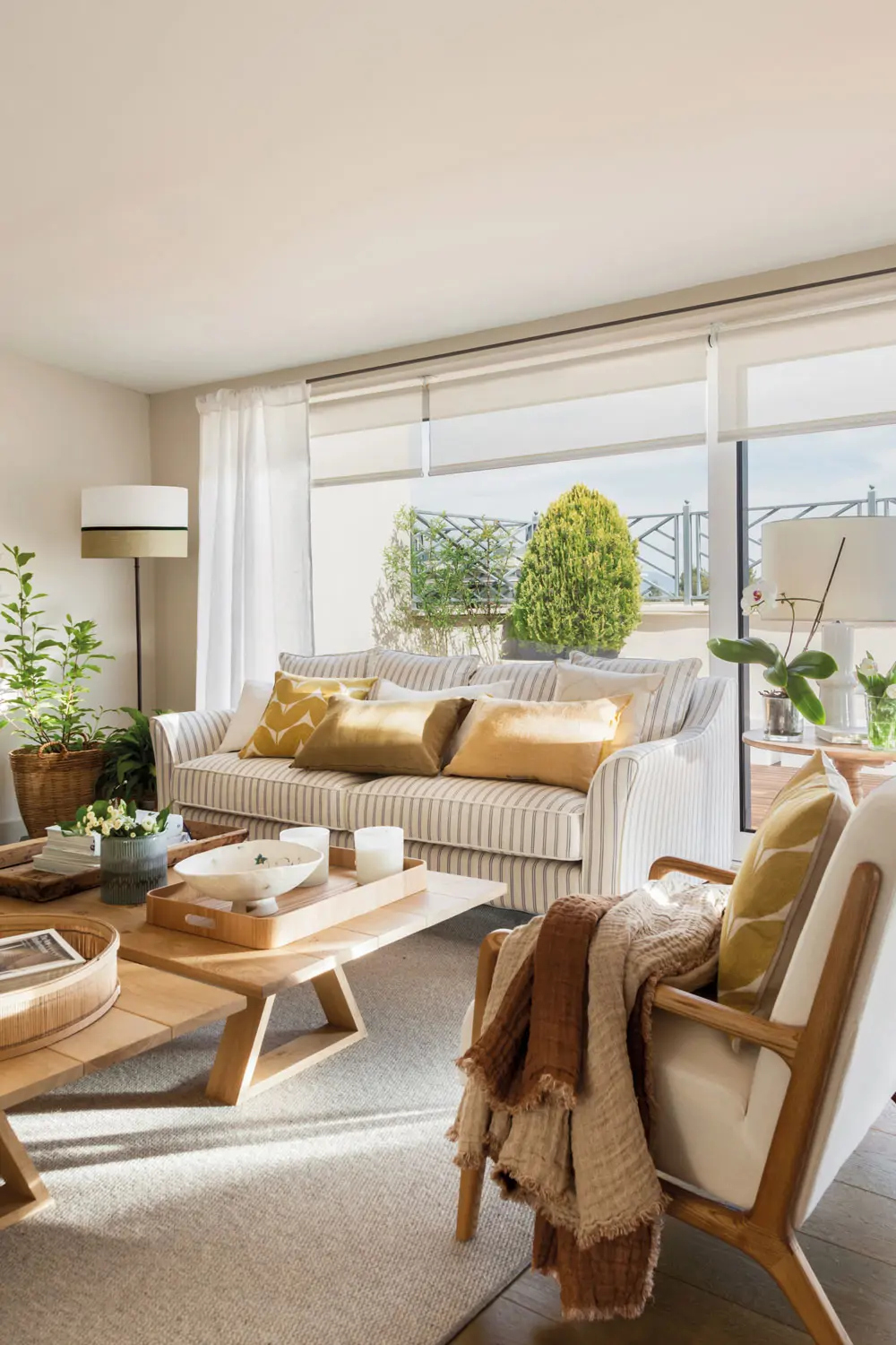Living room with striped sofa, armchairs and neutral curtains