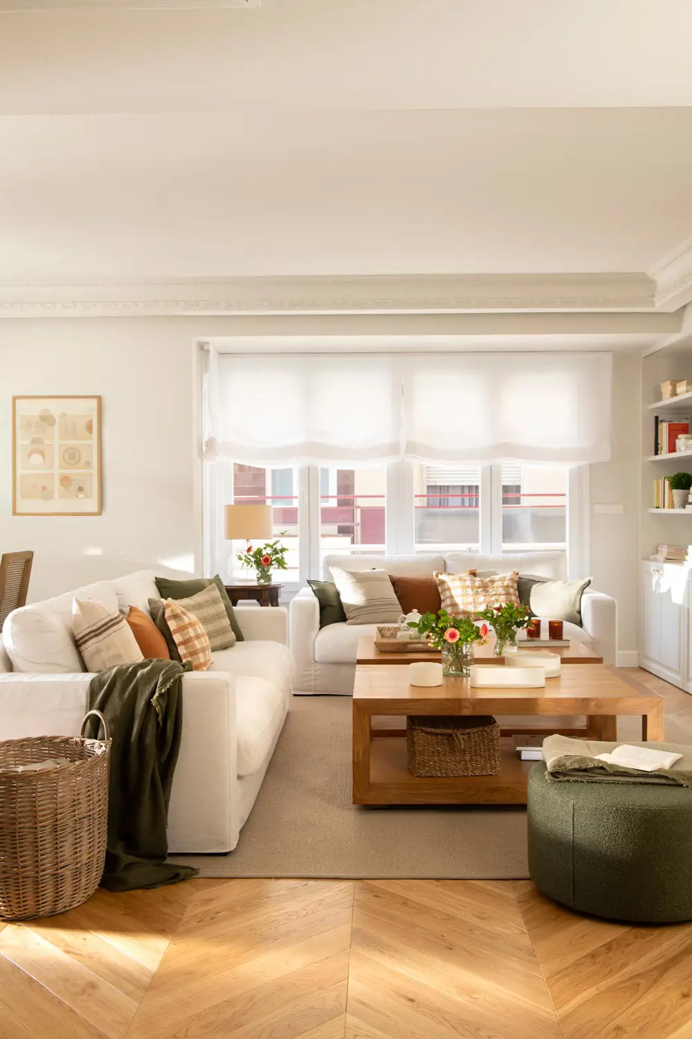 Living room with white sofas, wooden coffee table, green pouf and fibre basket